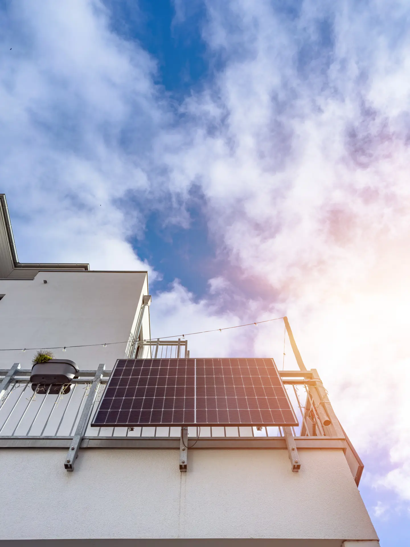 Glückliche Familie läuft mit Sonnenkollektoren in der Nähe ihres Hauses. Alternative Energie, Ressourcenschonung und nachhaltiges Lebensstilkonzept.